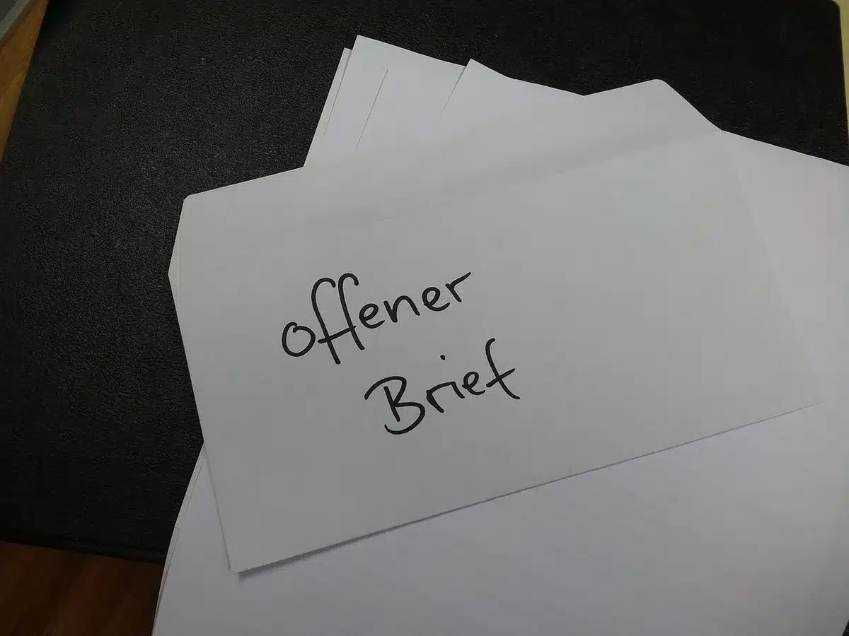 stack of unbranded legal envelopes and a single subpoena notice resting on top of a wooden table, an empty courthouse stairway blurred in the background