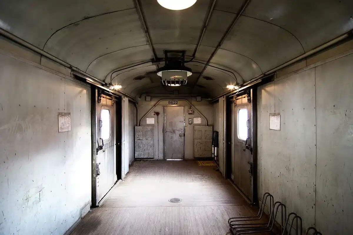 An empty government office hallway with a single chair under soft overhead lights, a folded jacket draped over the back of the chair, a closed door at the end of the corridor suggesting departure
