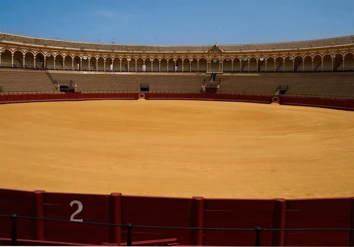 A tarp-covered building façade of a large performing-arts venue, empty plaza in front and no people, hinting at closure and uncertainty