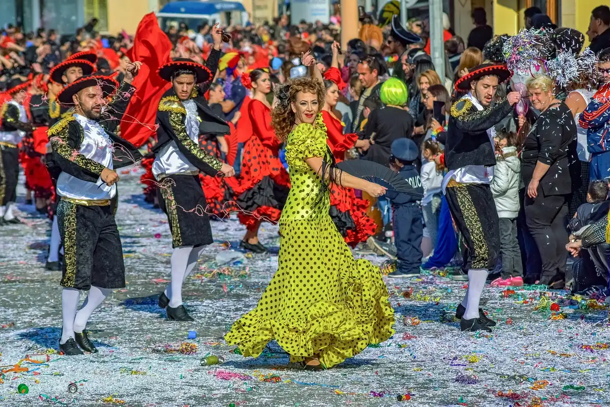A vibrant street scene with colorful floats and performers in traditional Caribbean carnival costumes, Eastern Parkway lined with spectators under bright sunlight, decorative banners and music stages visible, celebration atmosphere with drums and musical instruments