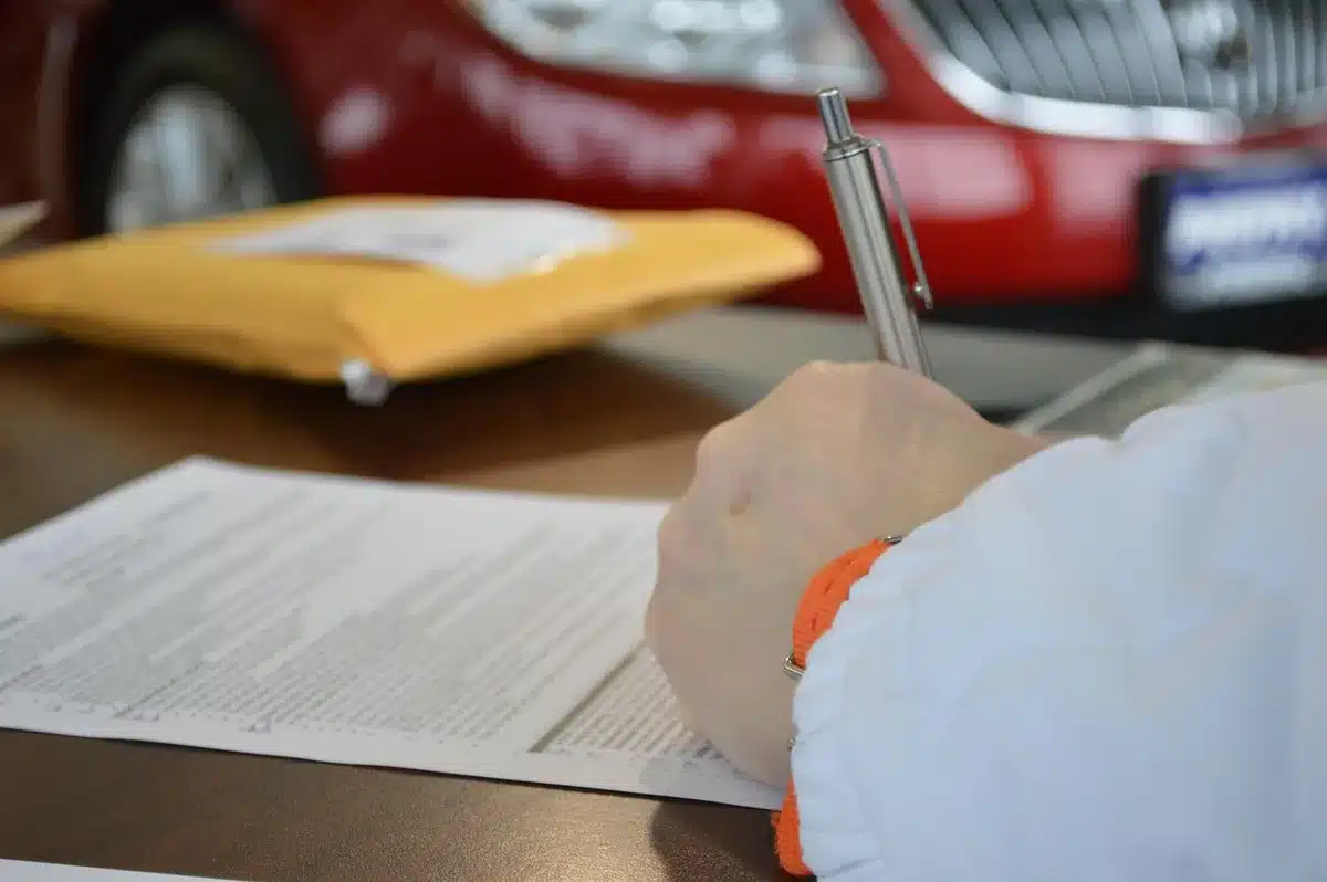 Stacks of trade documents and tariff schedules, marked with red pen edits, scattered across a desk