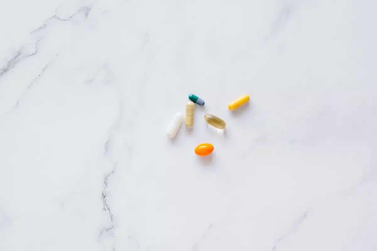 An empty pharmacy counter with a row of anonymous pill bottles and a printed benefit flyer on the counter, no logos or readable text