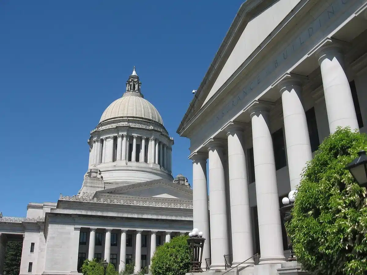 Capitol dome under morning light with American flag, government building representing legislative action