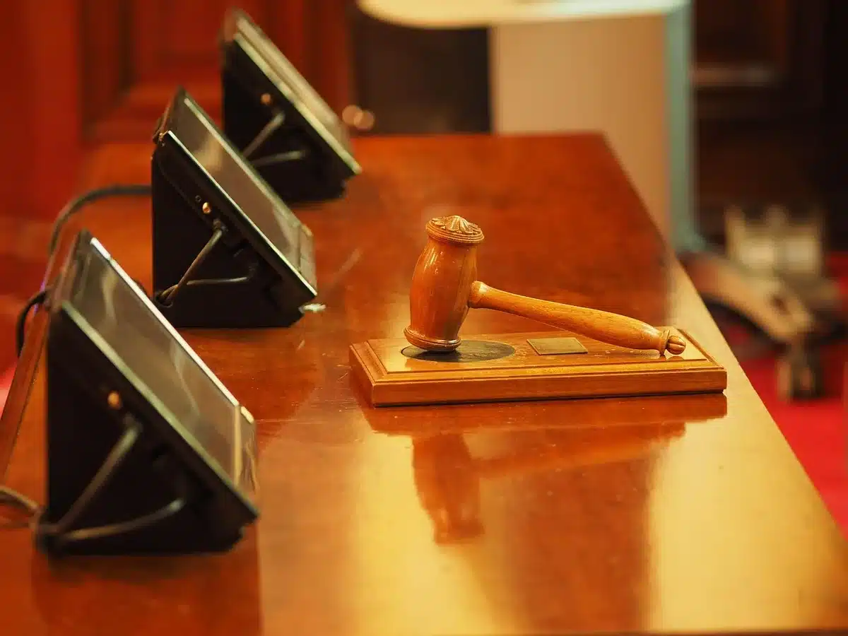 Close-up of an empty committee hearing desk with a microphone and a voting card, a pair of reading glasses left on top