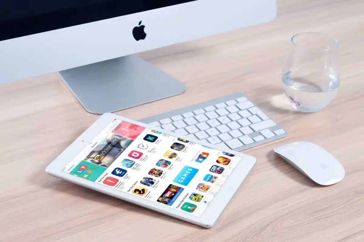 An anonymous silhouette of a person looking at a tablet showing blurred charts, a faint app icon grid visible but unbranded, late-afternoon office setting conveying product traction and attention