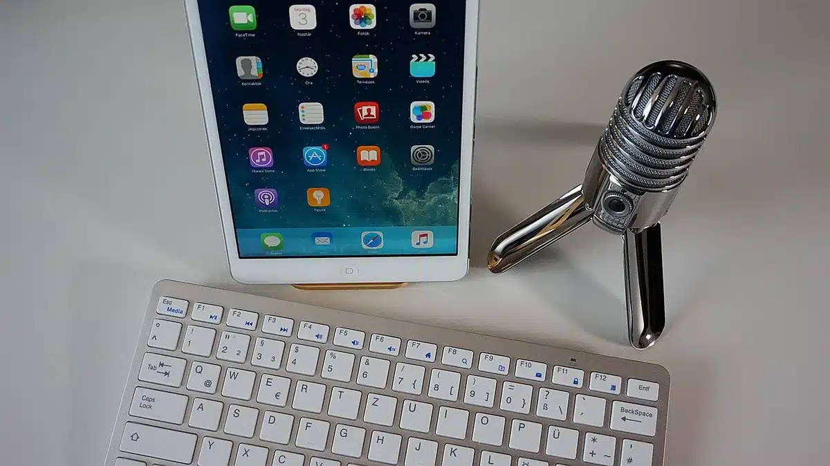 Close-up of a blank witness microphone on a wooden table, an empty chair behind it and blurred papers nearby