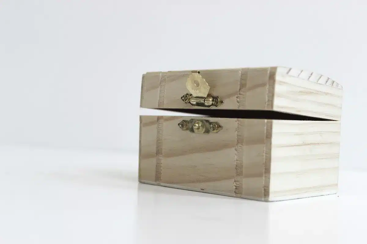 A single empty dressing-room chair under soft studio light, a small jewelry box on a nearby table suggesting a piercing choice, no people or logos visible