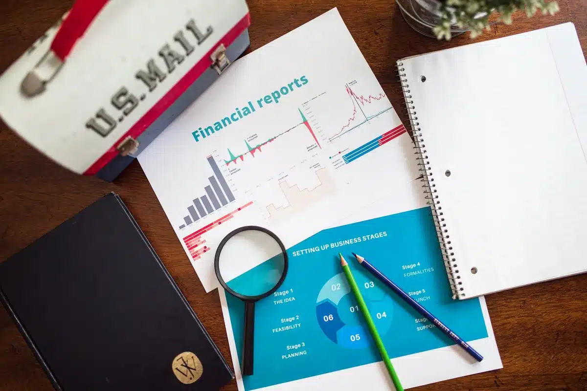 Anonymous close-up of an unbranded corporate boardroom table with an open financial report and a pen, paper charts visible but unreadable