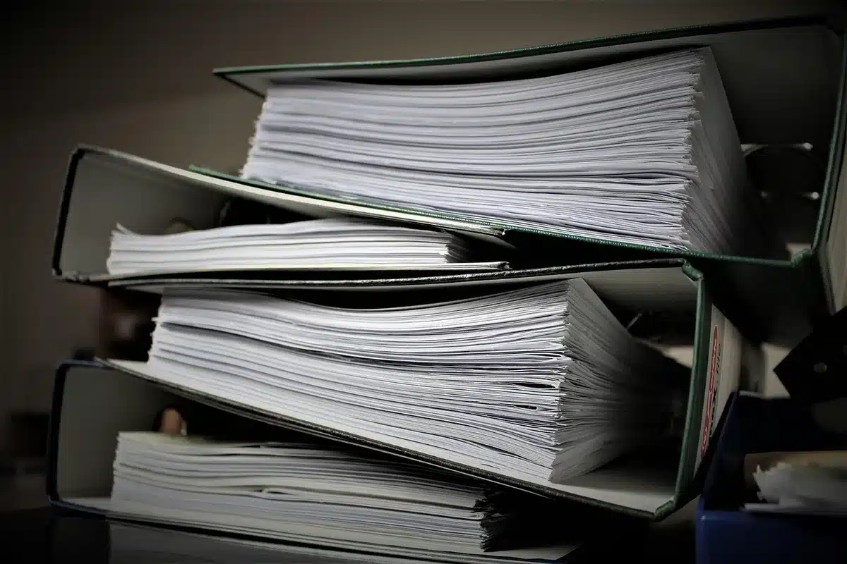 An anonymous office scene showing a printed SEC S-1 document on a desk beside a pen and a cup of coffee, hands not visible, casting morning light across the page
