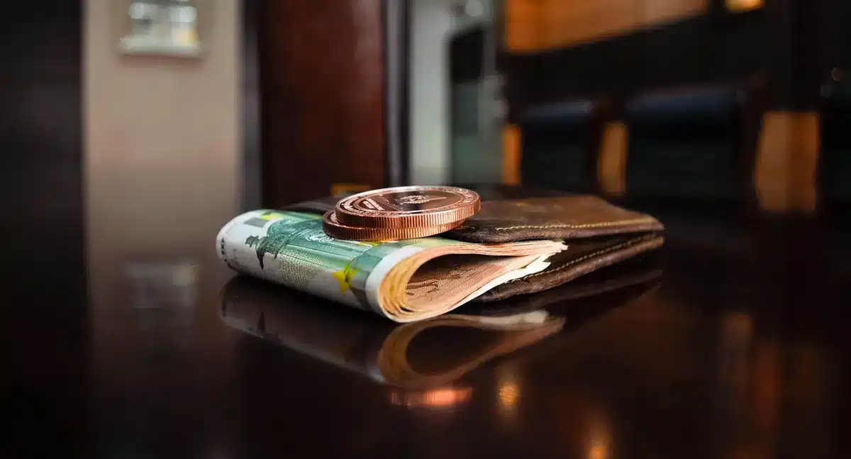 Close-up of anonymous hands holding a printed table of exchange rates and economic notes, pen resting nearby