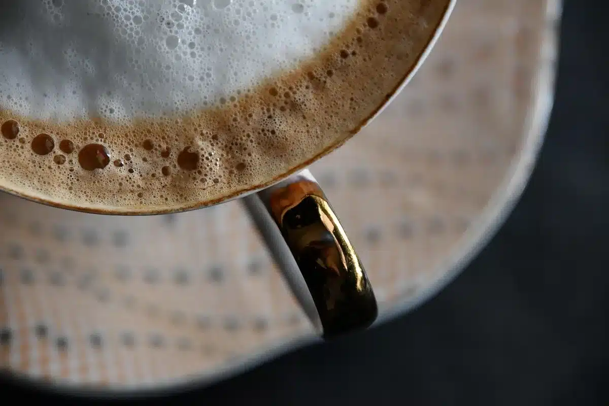 Close-up of a gavel resting on an empty desk beside a sealed envelope, sunlight across the wood; symbolic of legislative process and pending judgment