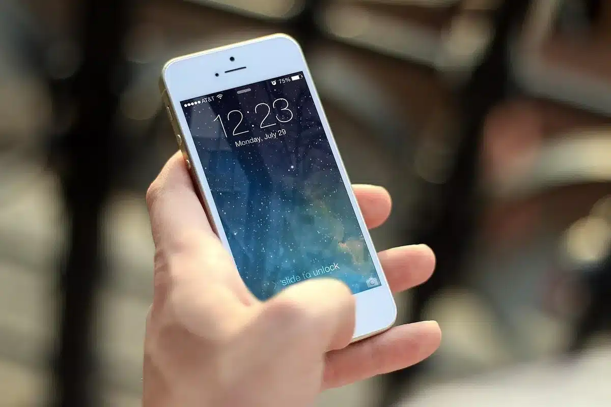 anonymous hands tapping a phone screen showing a restaurant profile with ratings and price icons, no brand or identifiable UI