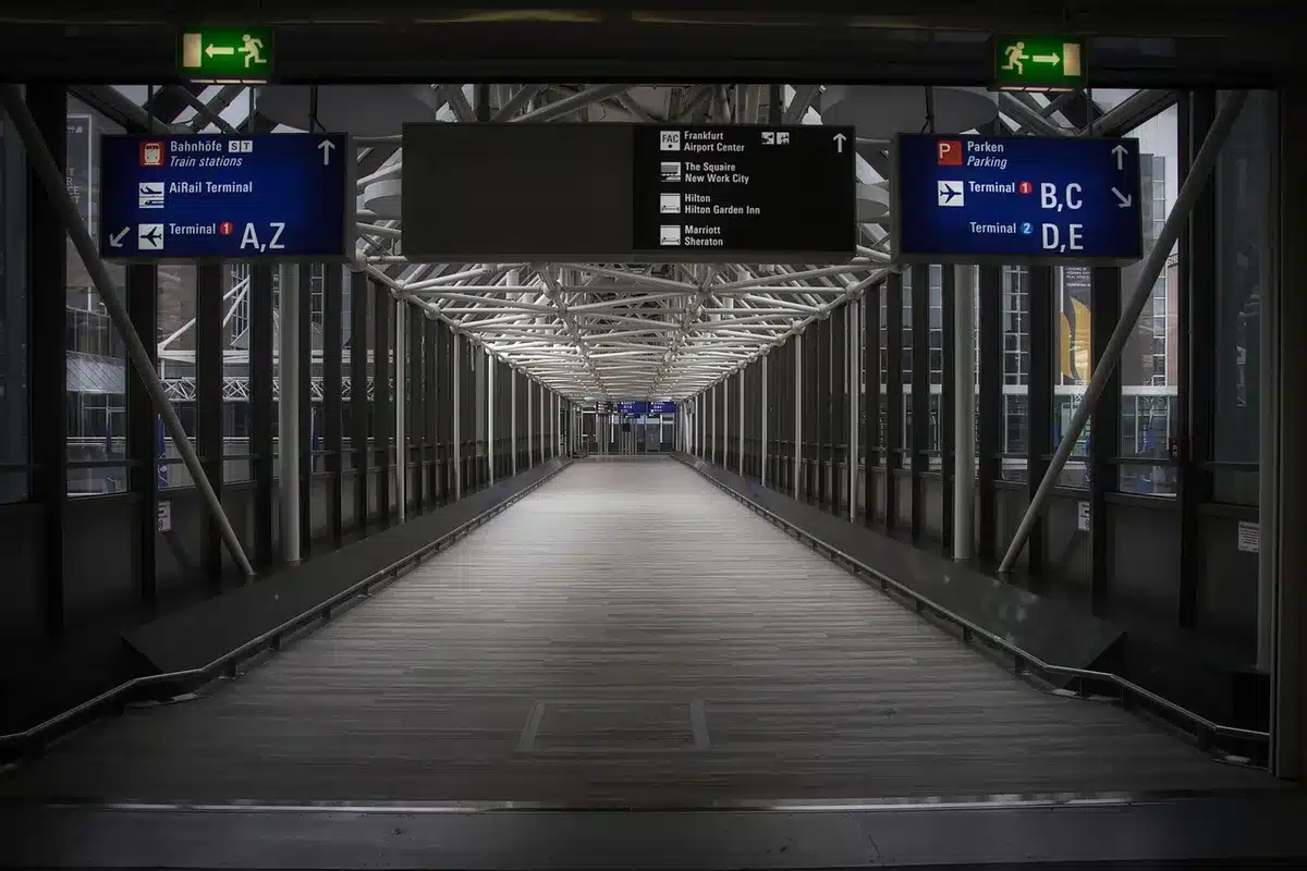 a small group of anonymous diplomats walking down a corridor past flagless doors, briefcases in hand, heads down in a brisk stride