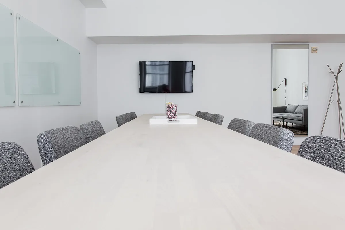 empty conference room with a single chair and a large wall screen showing a candlestick chart
