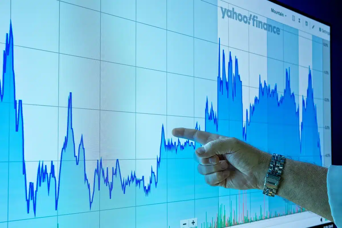 empty trading terminal with a single unbranded laptop showing a rising oil-price chart