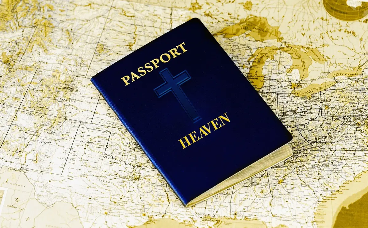 A close-up of anonymous hands holding a folded paper map beside a passport on a table, no names or logos visible, suggesting cross-border movement and legal paperwork