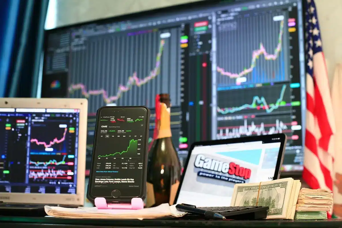 A stock market ticker display showing red and green numbers, a single trader's hand pointing at declining numbers, soft focus background of a financial trading floor, symbolizing economic uncertainty