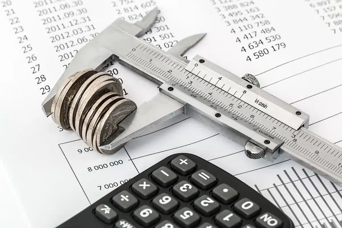 A nonprofit tax form or filing document on a desk, showing expense categories and dollar amounts, with a calculator and pen nearby, suggesting financial review and accountability