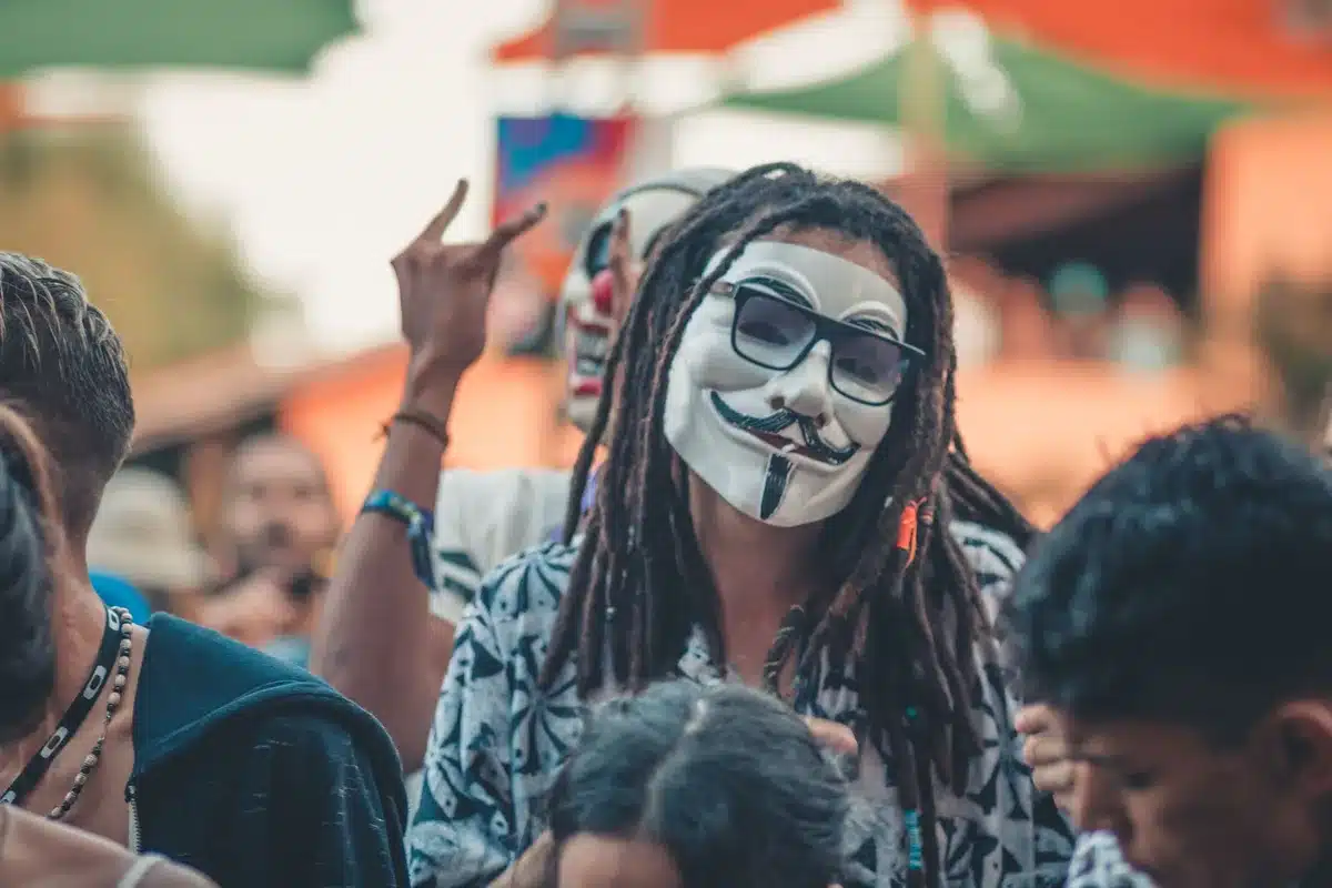 anonymous crowd outside a civic building, small groups looking at their phones, muted banners in background