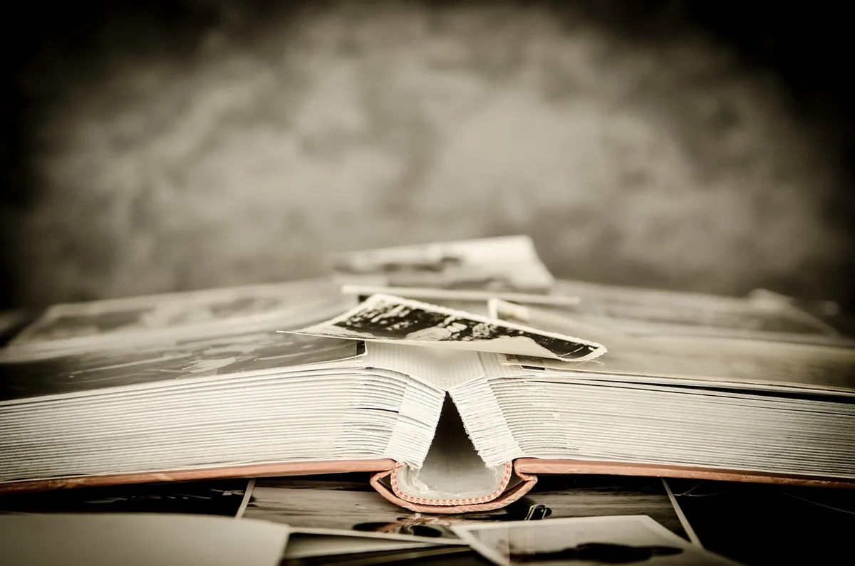 A close-up of anonymous hands flipping through a multi-page printed congressional resolution on a table, a pen beside the stack