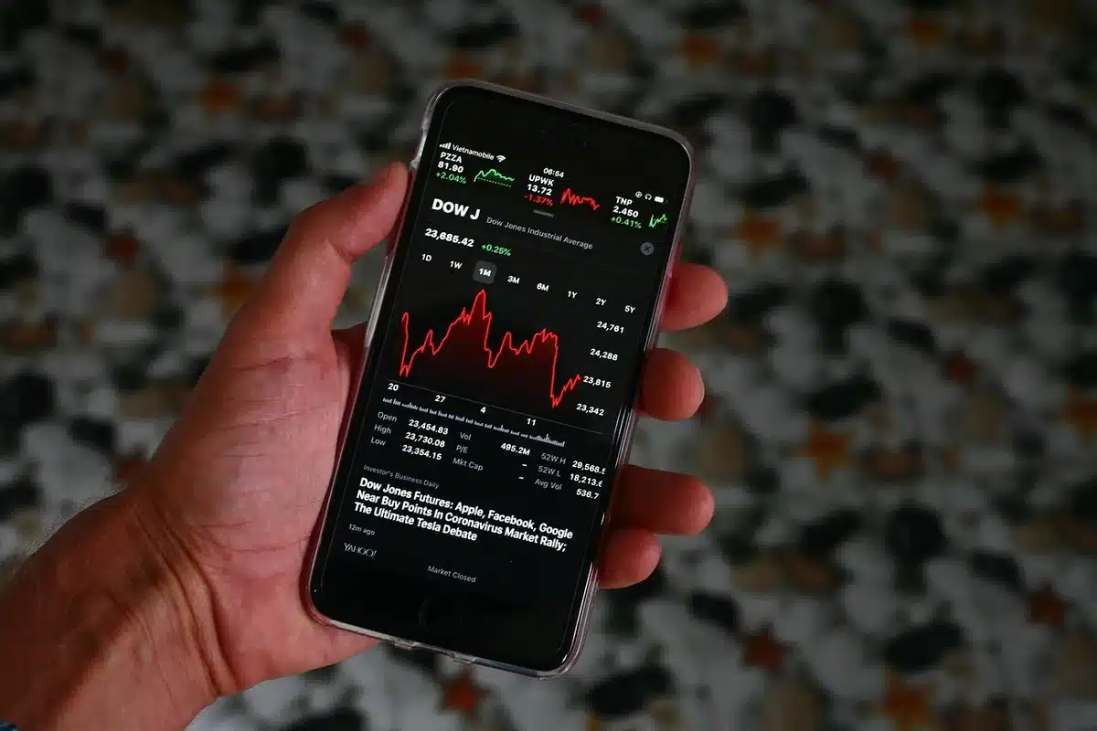 A split-screen financial trading floor showing traders reacting to market data, one side showing rising expectations on a glowing screen, the other side showing concern and tension. Neutral professional attire, anonymous faces.