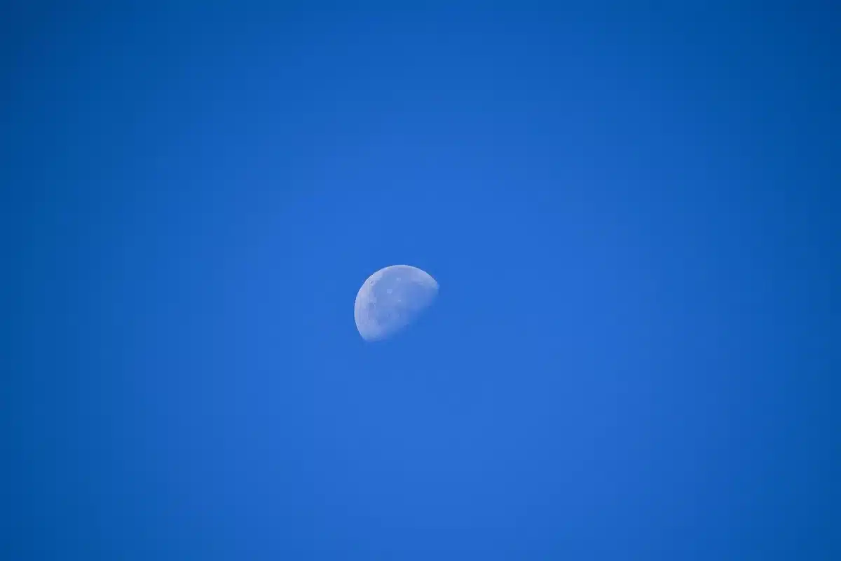 Close-up of a generic satellite silhouette against a dark sky, solar panels outlined but no insignia, a faint Earth curve on the horizon &mdash; anonymous, unbranded orbital hardware