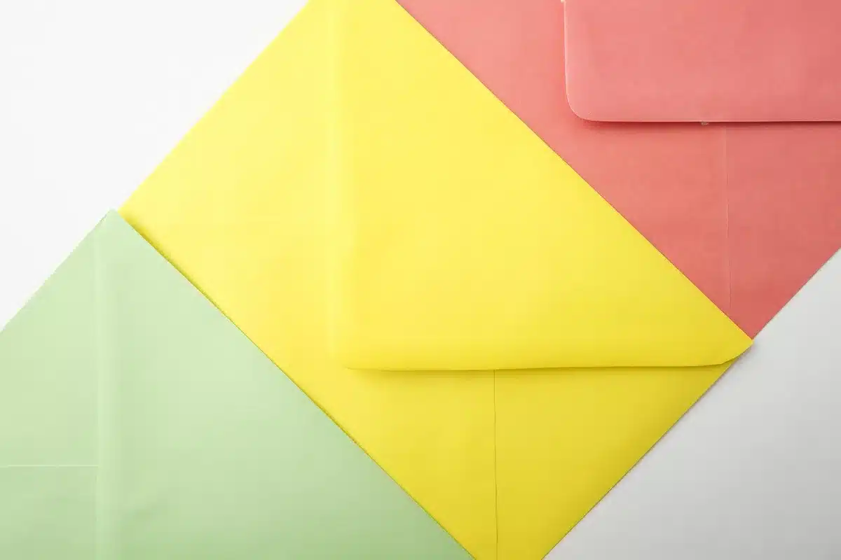 An anonymous close-up of a handful of unbranded mail ballot envelopes fanned on a plain table, an official-looking clip holding them together, no names or markings visible