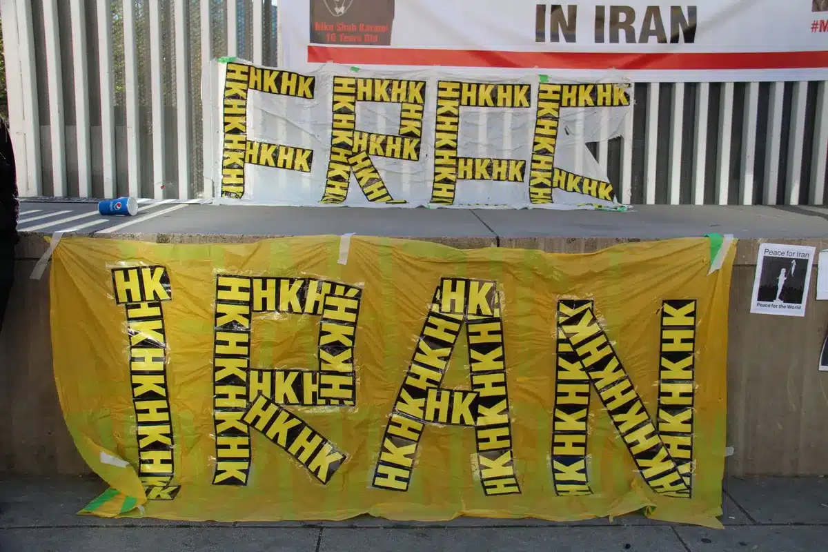 An empty campaign staging area with a generic podium and scattered campaign flyers on a table, a large blank banner in the background, no logos or names