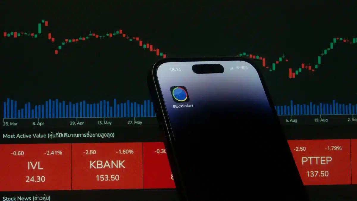A dimly lit trading screen showing anonymous oil price charts and candles, a single hand pointing at a volatile spike on the screen