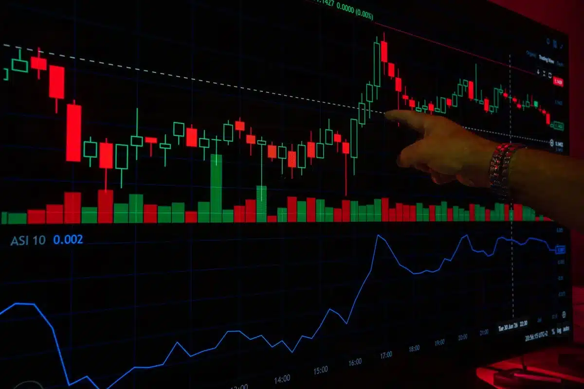 Anonymous group of traders watching large overhead screens showing a sharp downward index move; faces blurred and unbranded
