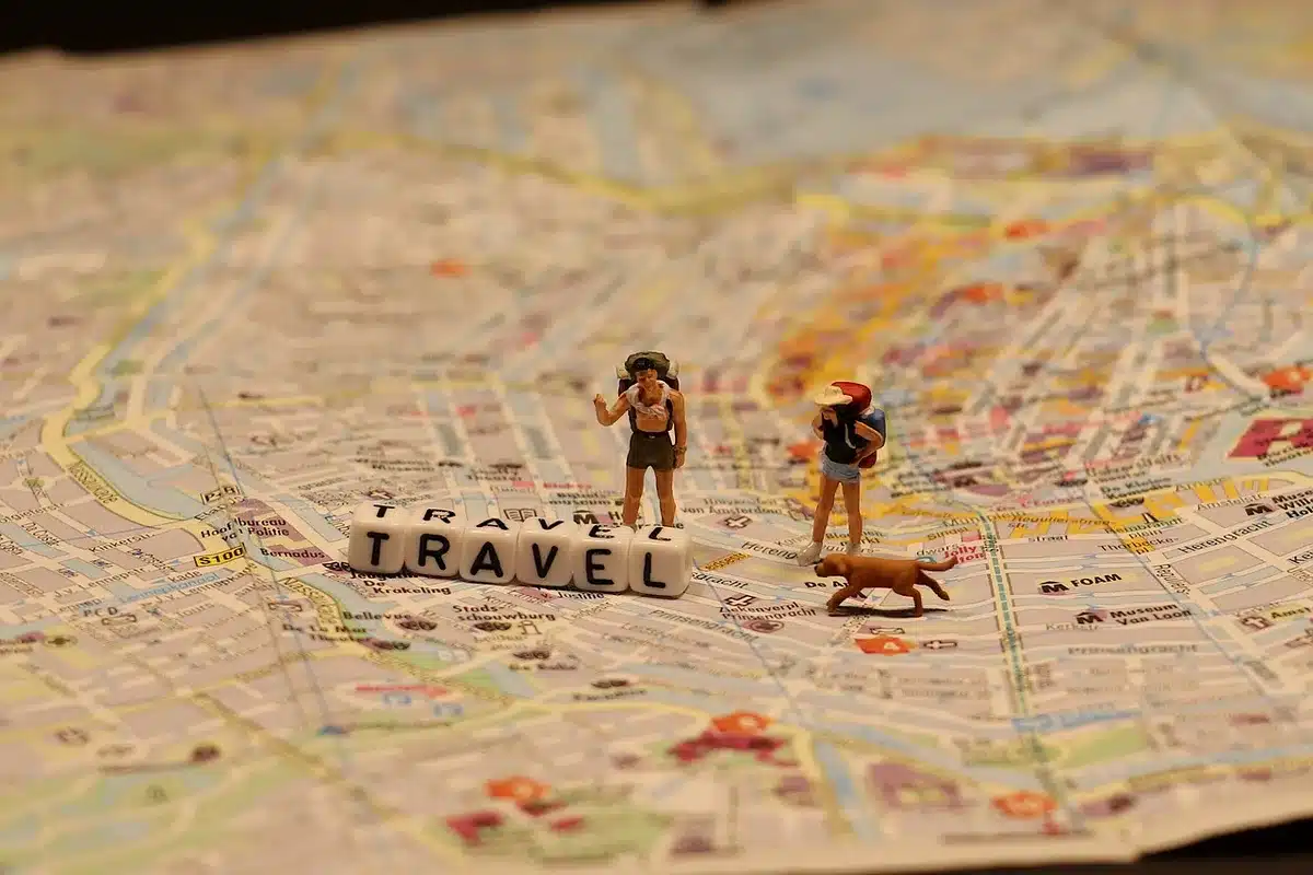 Close-up of a small 3D-printed miniature sculpture on a table next to informational leaflets, hands blurred in the background; no identifiable people or text