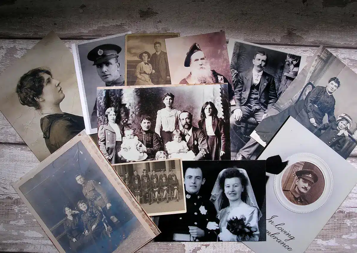 An empty neighborhood front porch with a weathered chair and a folded family photograph lying face down on a table, suggesting estrangement and private family conflict